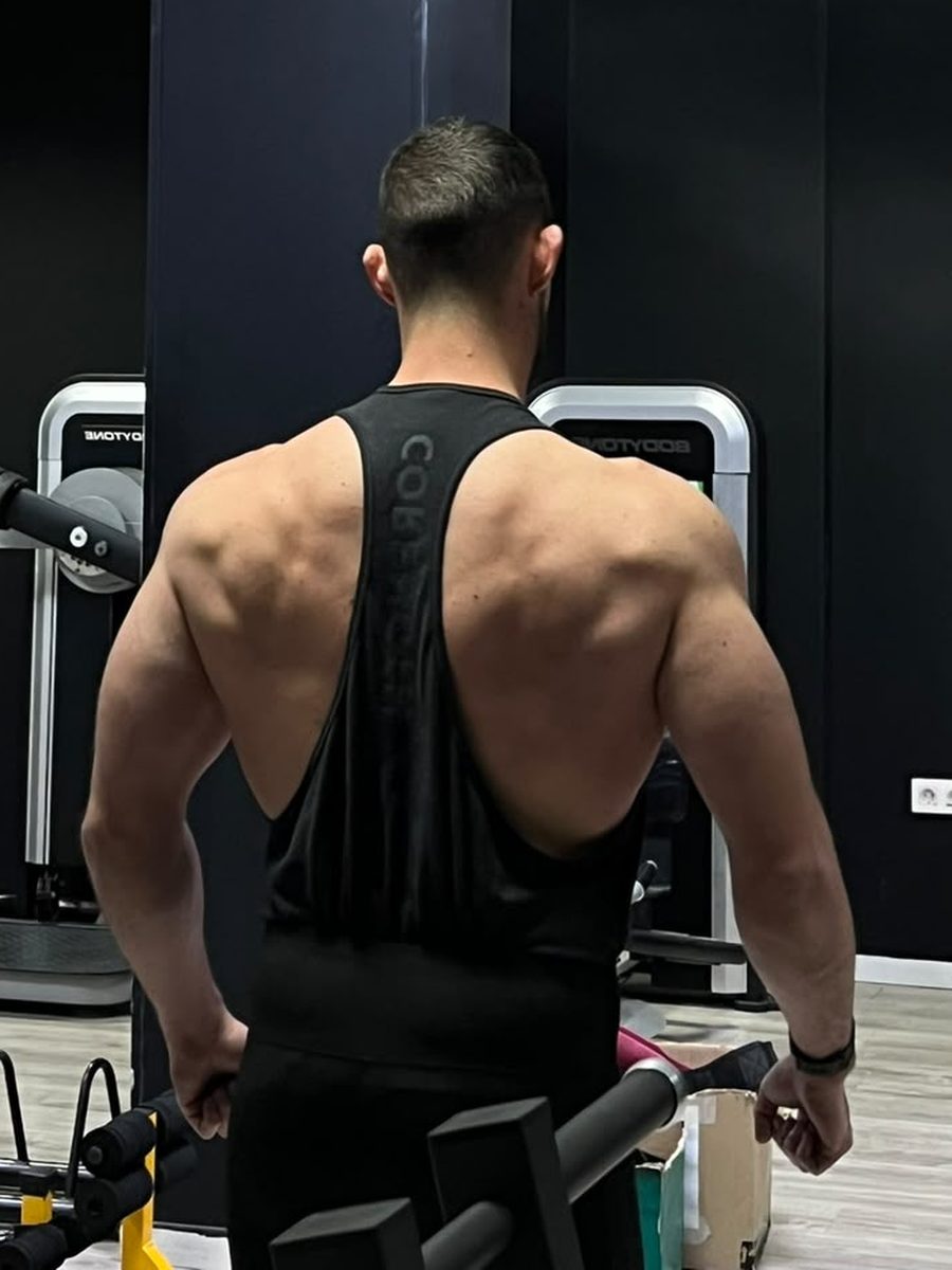 Melli de espaldas en el gimnasio, entre las máquinas