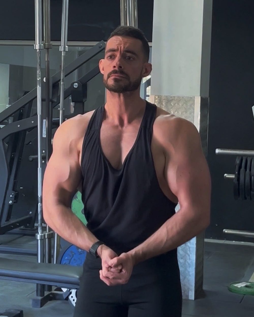 Melli, entrenador personal, de pie en el gimnasio